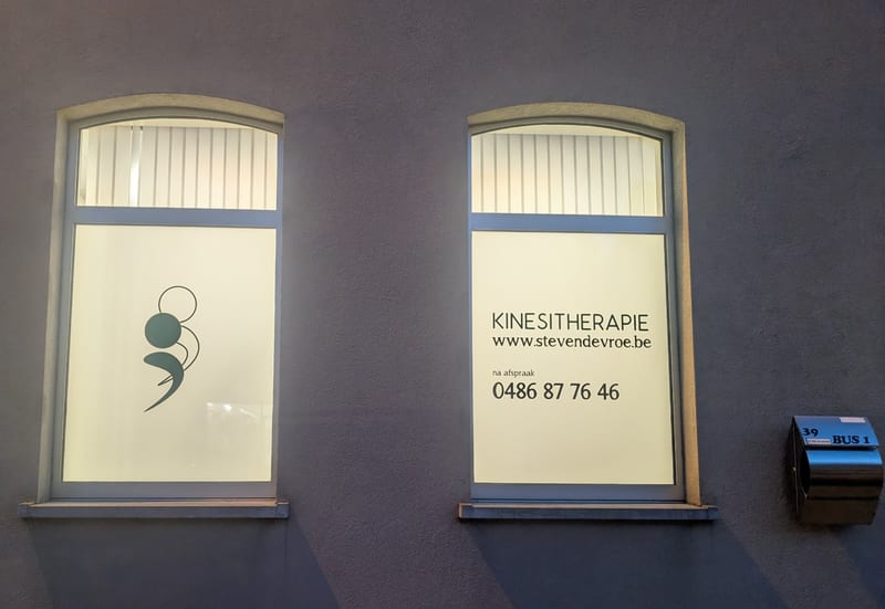 Gevel van de praktijk met de raamstickers van Kinesitherapie Steven De Vroe